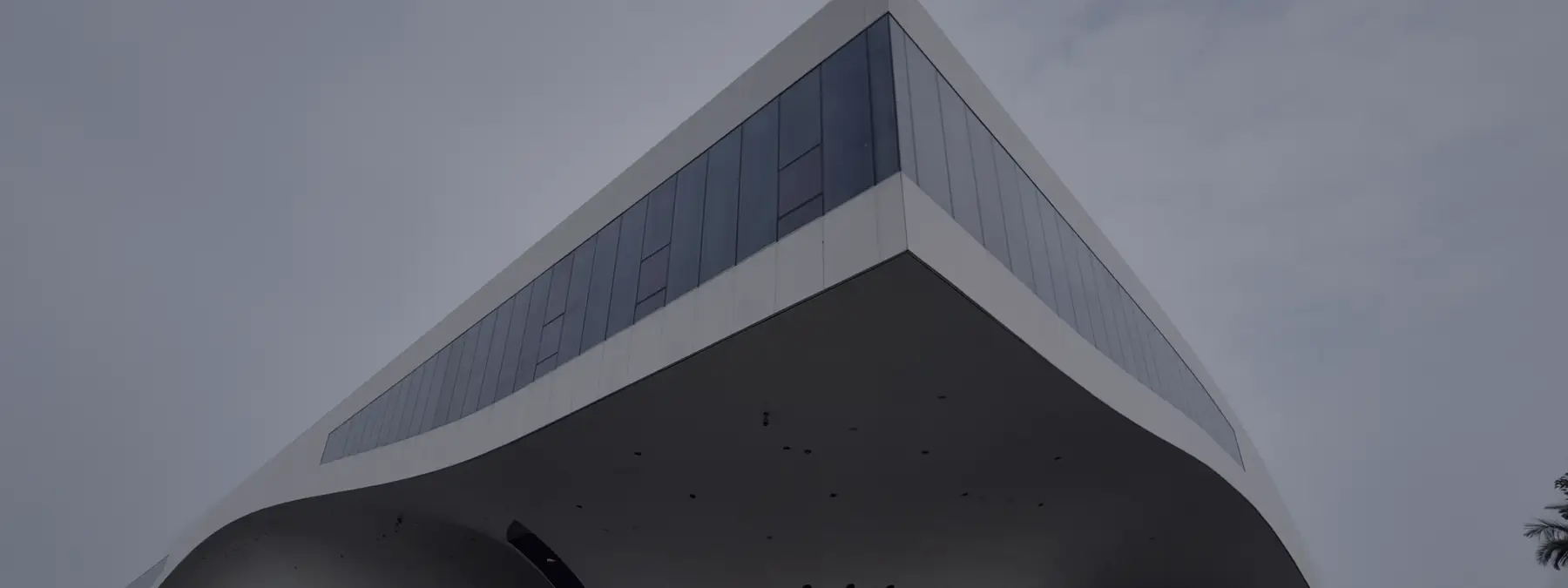 A contemporary building rising against the sky at dusk.
