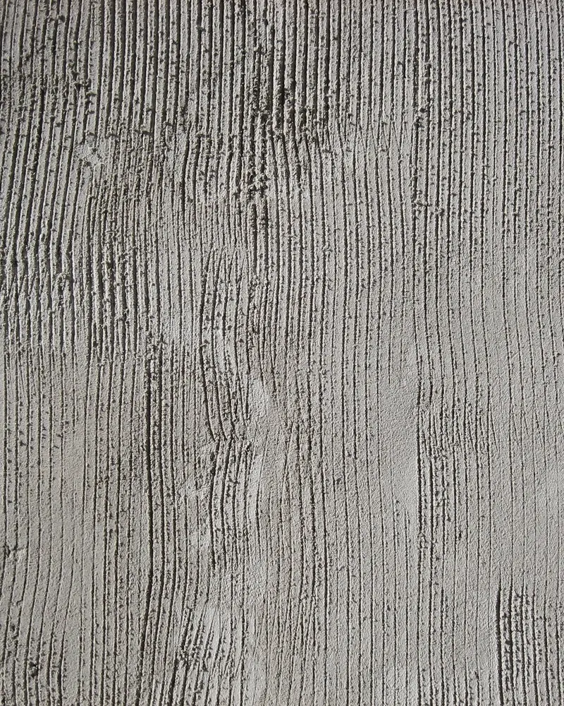 Board-formed concrete, the grain of the timber shuttering printed into its grey surface.