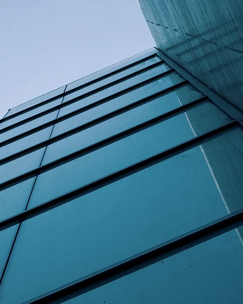 A low-iron glass edge, its polished arris set into a fine shadow gap.